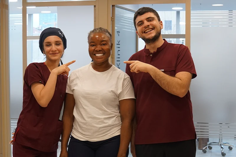 Diş tedavisi sonrası mutlu hasta ve klinik ekibi