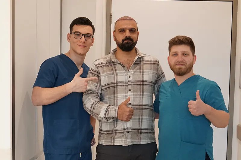 Happy patient and clinic team after hair transplant